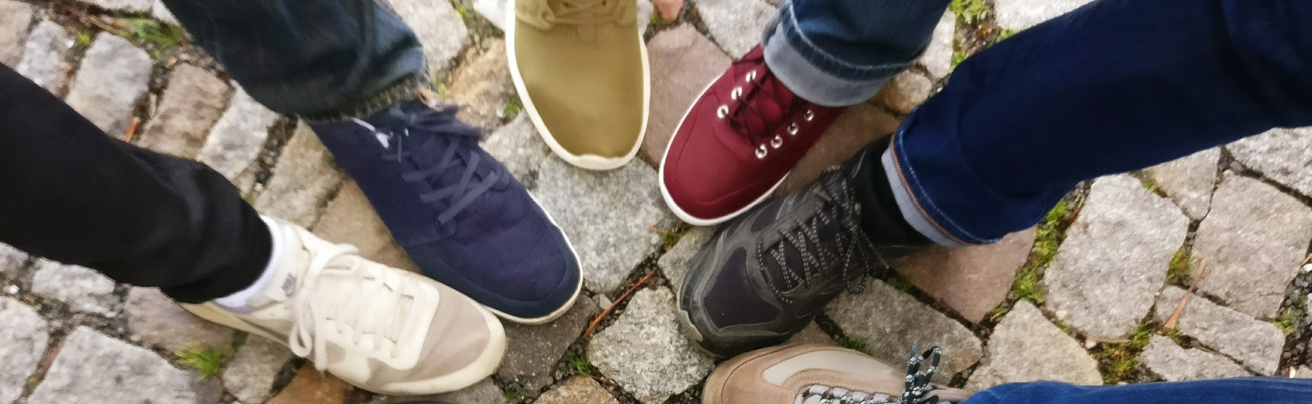 People standing in circle with legs and shoes pointing inward