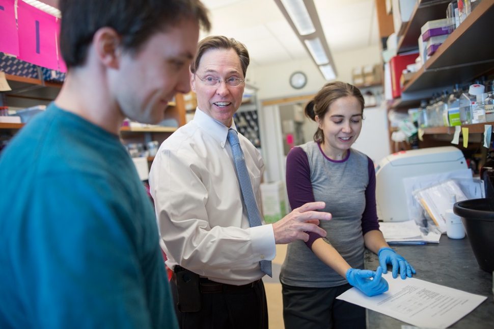 Terence S. Dermody, MD (center) talking with two lab technicians