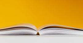 Book open flat on table with yellow background